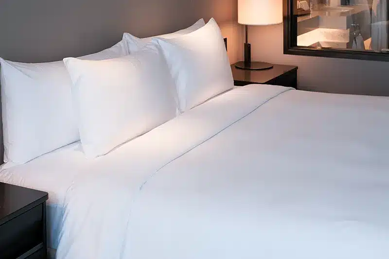 bed with white covers in hotel room