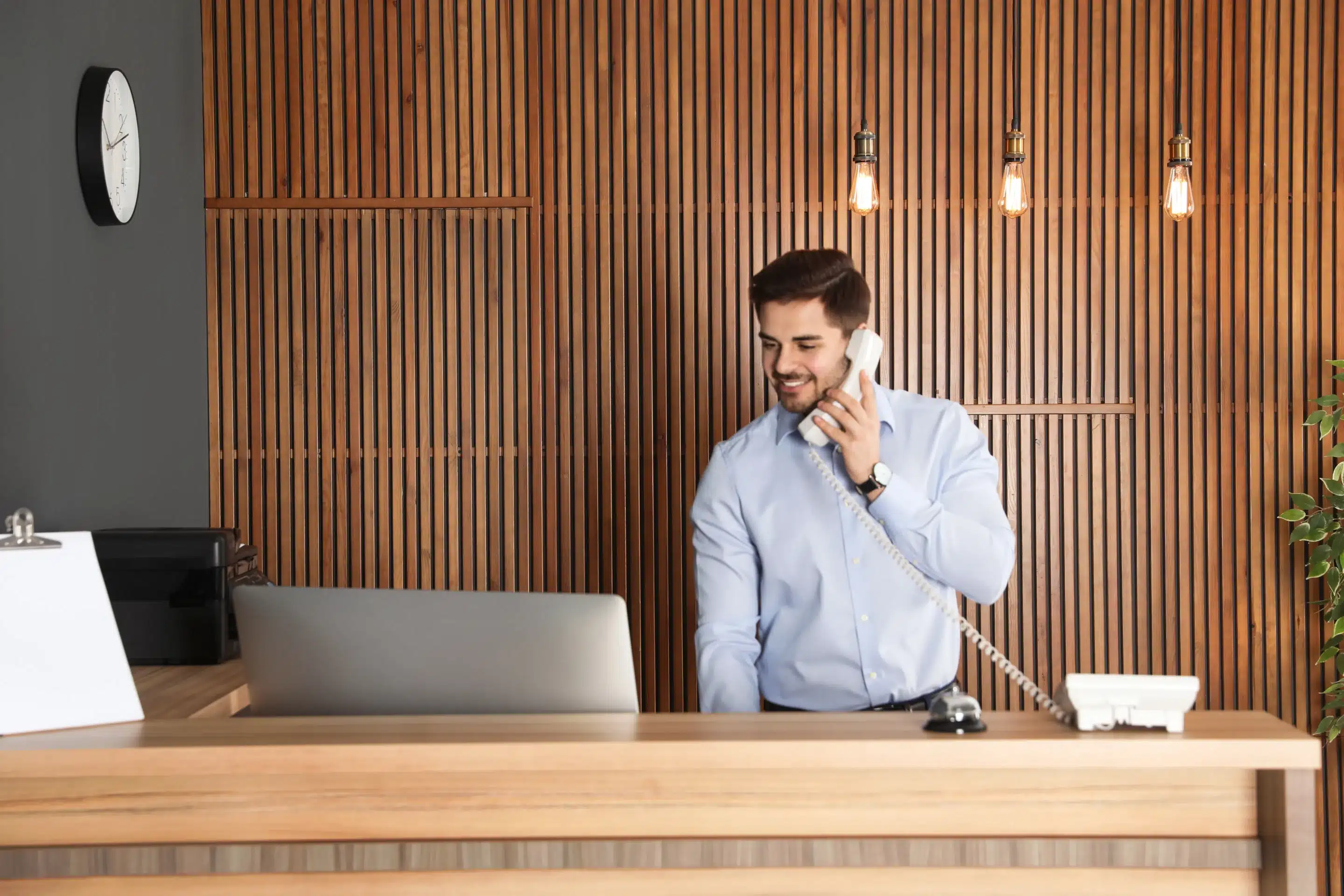 guy at front desk holding phone