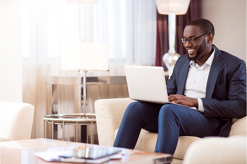 man using laptop in a common room lounge