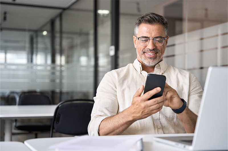 man using mobile phone in a large office