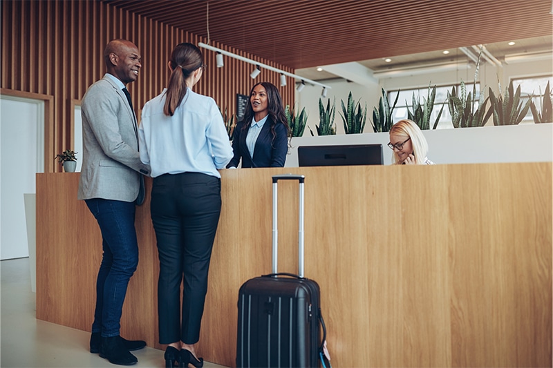 two guests checking in at a hotel front desk