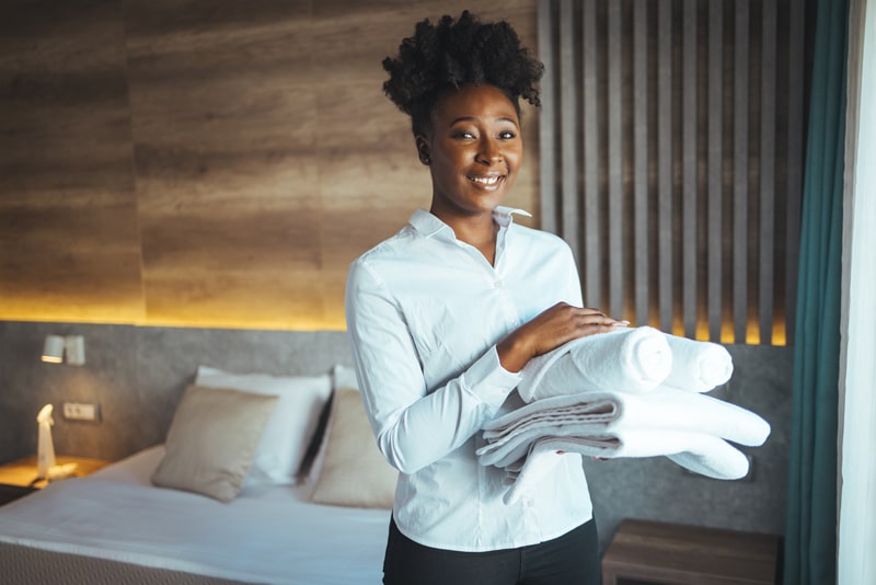 woman holding towels in a bedroom