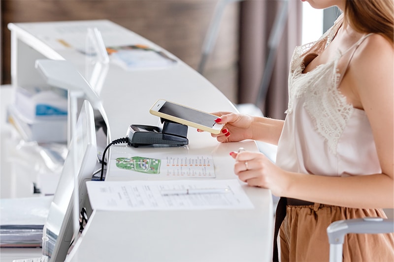 woman using contactless checkin at the front desk