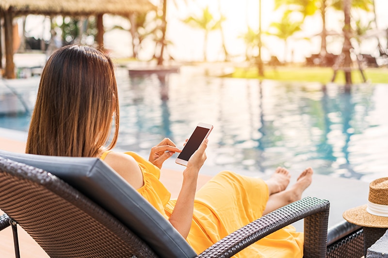 hotel guest at pool with phone